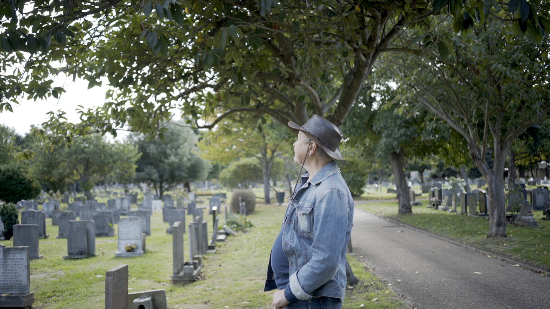 Terry O'Sullivan standing among the graves in a tree-lined cemetery
